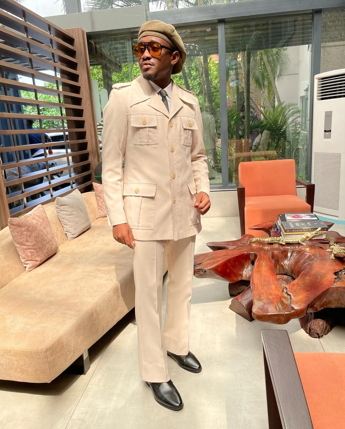 Trepetsi client in cream safari tailoring with amber sunglasses